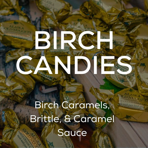 White text stating "Birch Candies: Birch Caramels, Brittle & Caramel Sauce" in front of several birch caramels in gold wrapping on a wooden surface