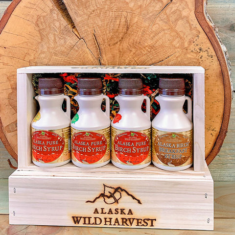 Four bottles of Alaska Pure Birch Syrup in a wooden crate with 'Alaska Wild Harvest' branding.