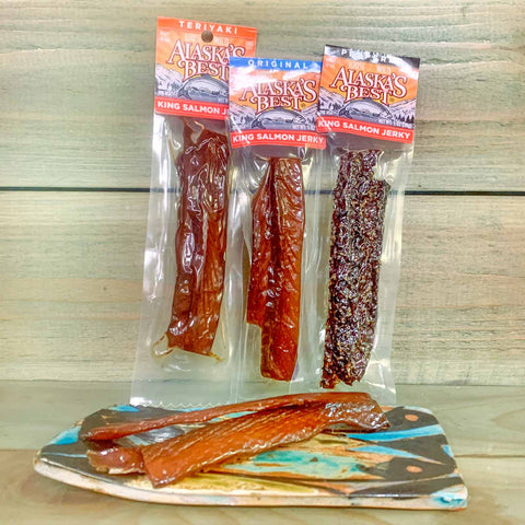 Alaska's Best King Salmon Jerky packages on a decorative plate with a wooden background