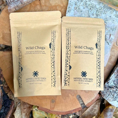 Wild Chaga Tea 2oz and 4oz craft bags on a log