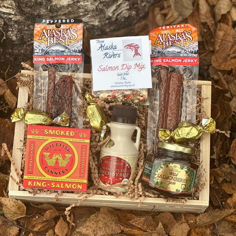 Salmon Lovers Gift basket with Alaska's Best salmon jerky, salmon dip mix, and other Alaska-themed products on a leafy background.